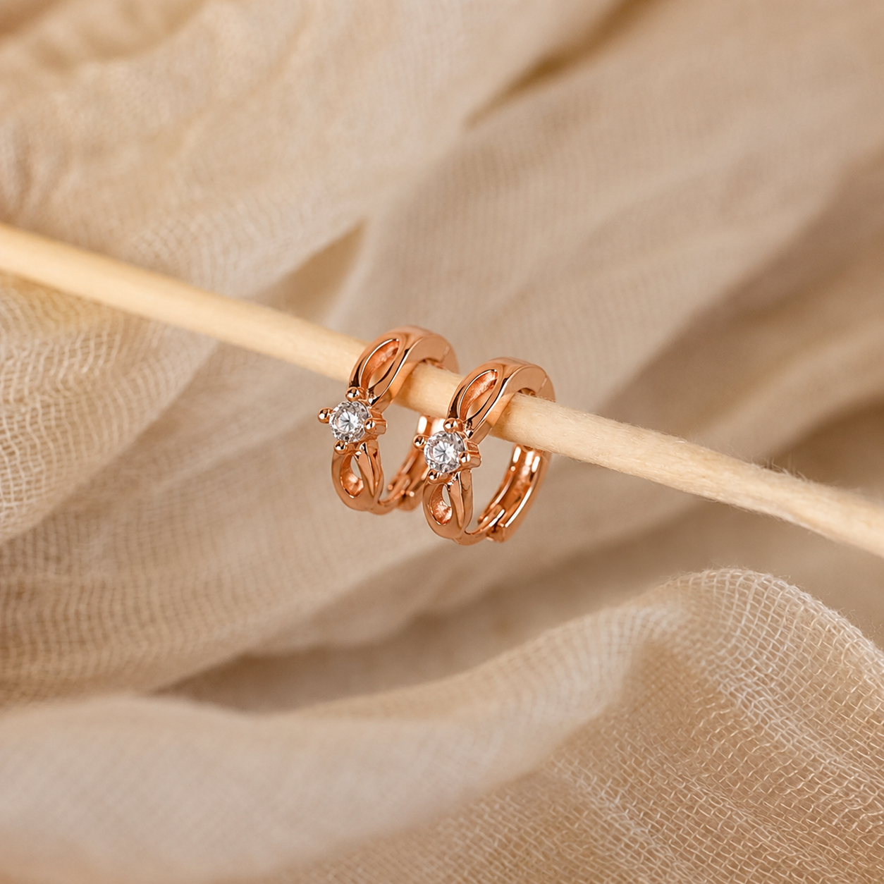 Rose gold rings with diamonds on a beige fabric background